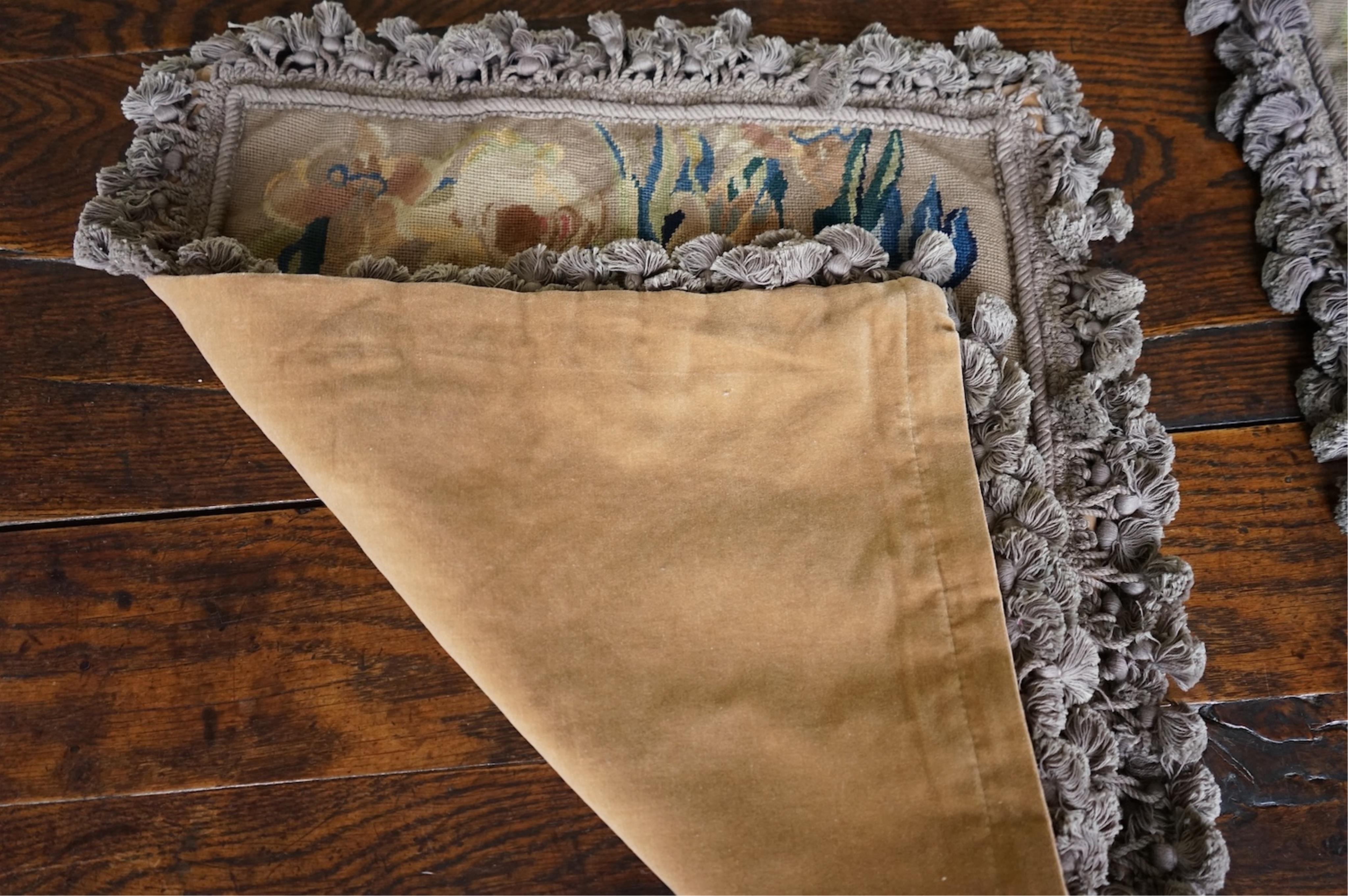 Four large rectangular wool worked cushion covers, with a still life design of a bowl of roses, tulips and daffodils. Embroidered in very muted colours, with ornate tasseled braid and velvet backing. 48cm high x 39cm wid